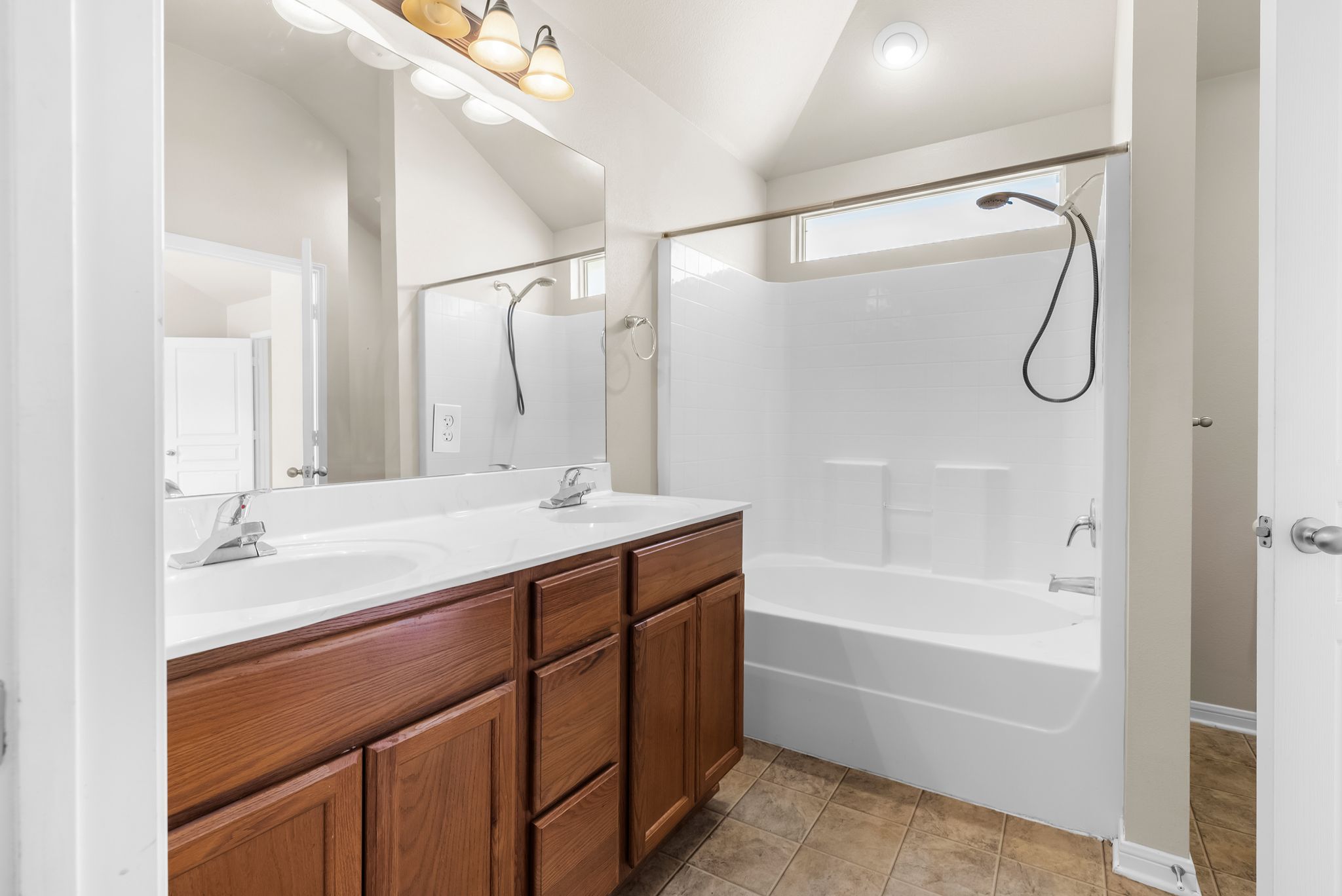 7719 Fieldstone Drive Temple, TX 76502 - Photo 25 of 37 Full bath featuring double vanity, vaulted ceiling, tub / shower combination, and light tile patterned flooring