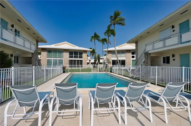 a view of a patio with table and chairs with wooden fence