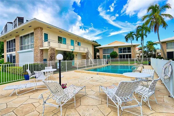 a view of a house with a swimming pool and sitting area