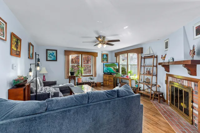 a living room with furniture a fireplace and a large window