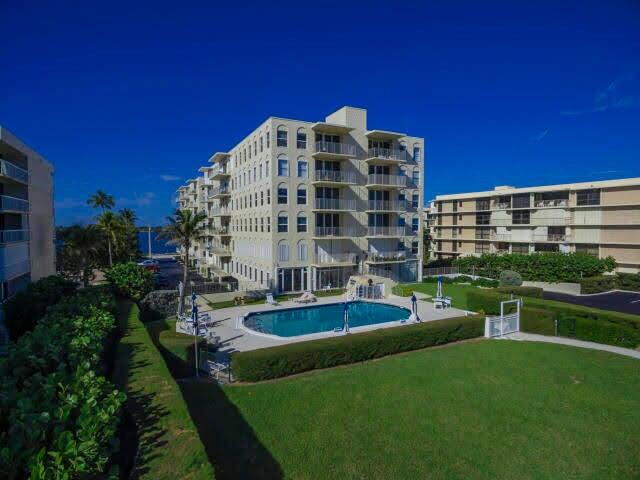 3230 South Ocean Boulevard, Unit E610 Palm Beach, FL 33480 - Photo 11 of 31 a view of a tall building with a yard