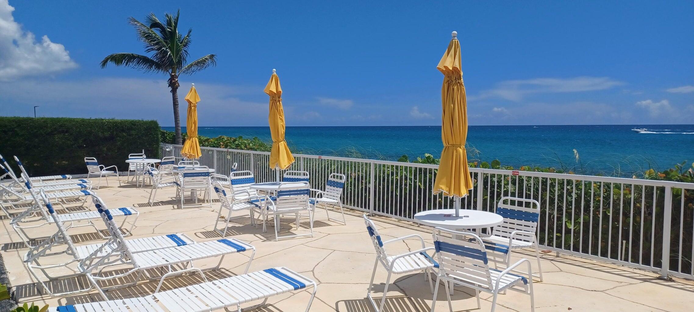 3230 South Ocean Boulevard, Unit E610 Palm Beach, FL 33480 - Photo 13 of 31 a view of a patio with a table chairs and a patio
