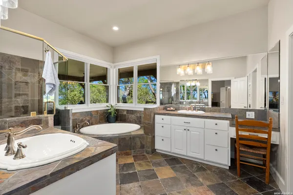 a bathroom with a granite countertop sink and a large window