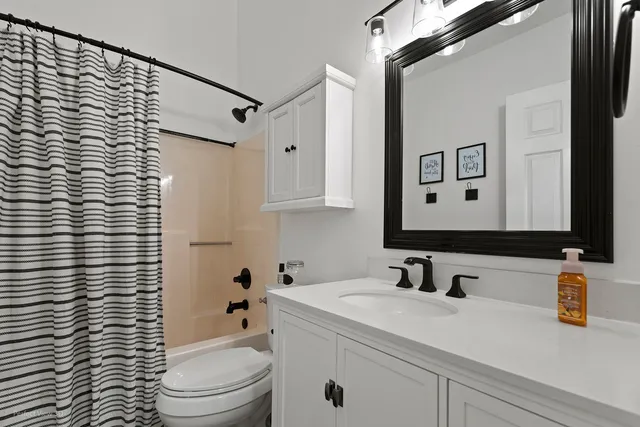 a bathroom with a sink a toilet and shower curtain