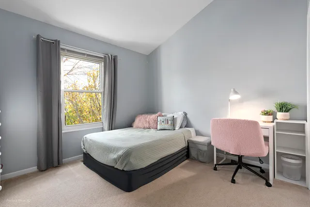a bedroom with a bed chair and window