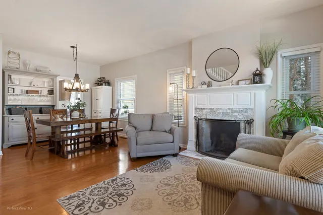 a living room with furniture a fireplace a rug and a chandelier