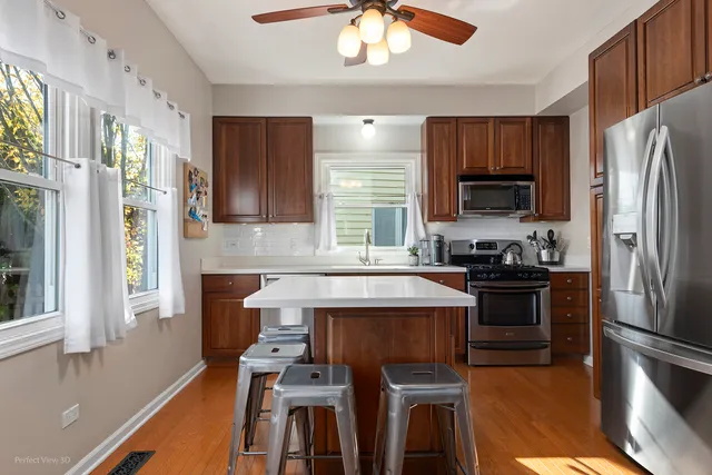 a kitchen with stainless steel appliances a stove refrigerator sink and microwave
