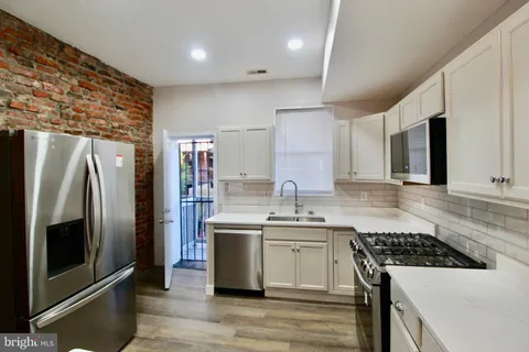 a kitchen with stainless steel appliances a sink stove and refrigerator