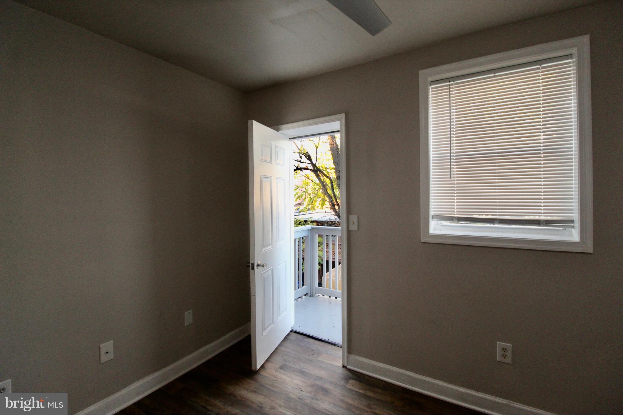 434 East 28th Street Baltimore, MD 21218 - Photo 19 of 37 a view of an empty room with wooden floor and a window