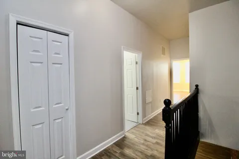 a view of hallway with stairs and wooden floor