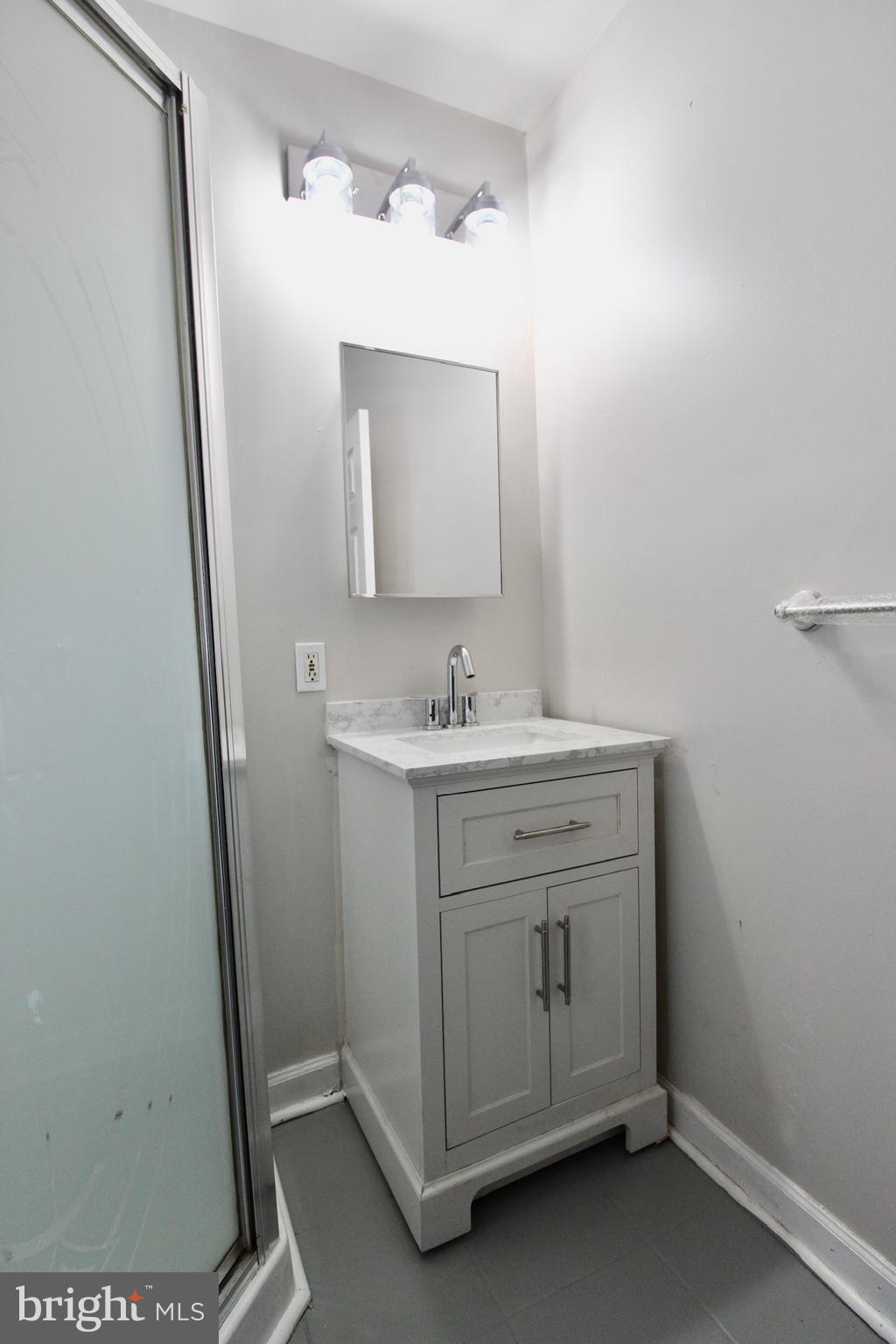 434 East 28th Street Baltimore, MD 21218 - Photo 23 of 37 a bathroom with a sink a mirror and a vanity
