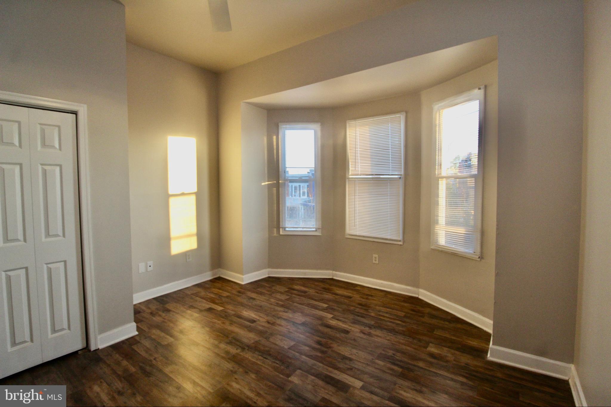 434 East 28th Street Baltimore, MD 21218 - Photo 25 of 37 a view of an empty room with wooden floor and a window