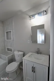 a bathroom with a toilet sink and mirror