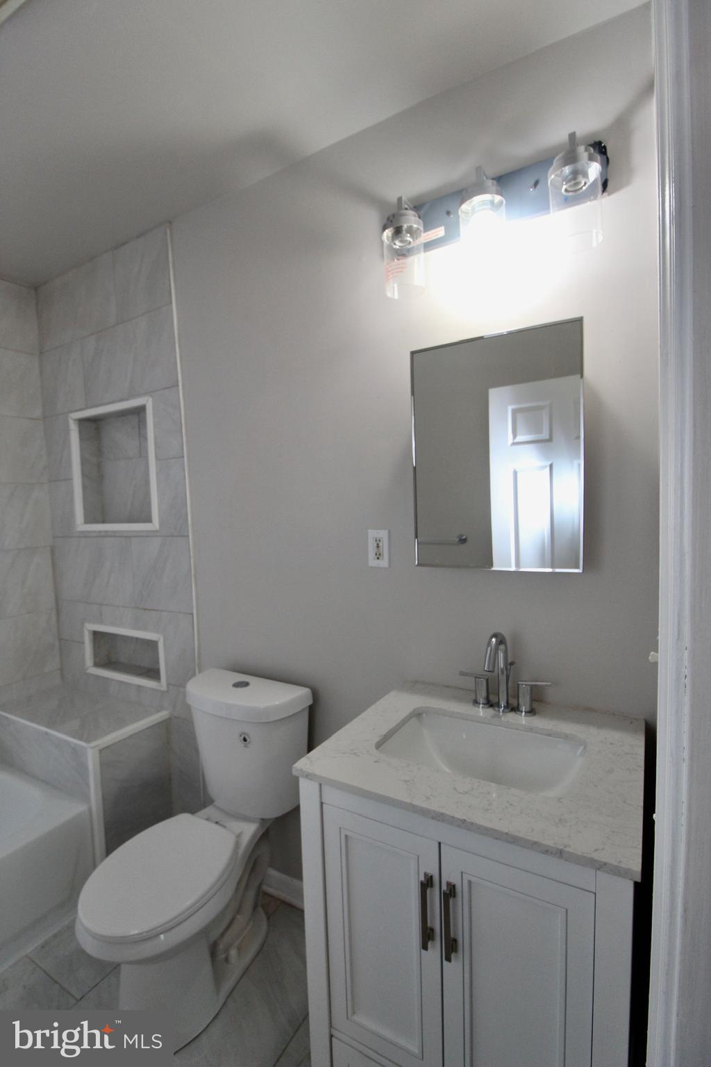 434 East 28th Street Baltimore, MD 21218 - Photo 26 of 37 a bathroom with a toilet sink and mirror