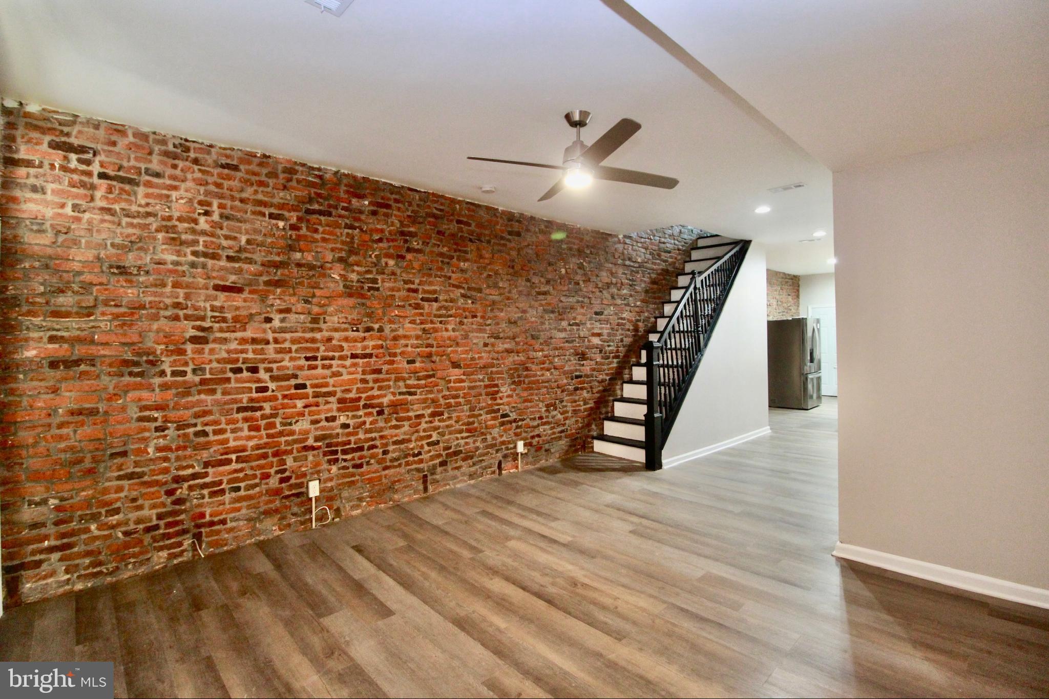 434 East 28th Street Baltimore, MD 21218 - Photo 6 of 37 a view of an empty room with wooden floor and stairs