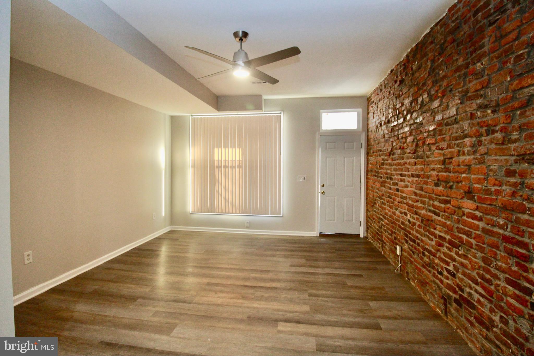434 East 28th Street Baltimore, MD 21218 - Photo 7 of 37 a view of an empty room with wooden floor and a window