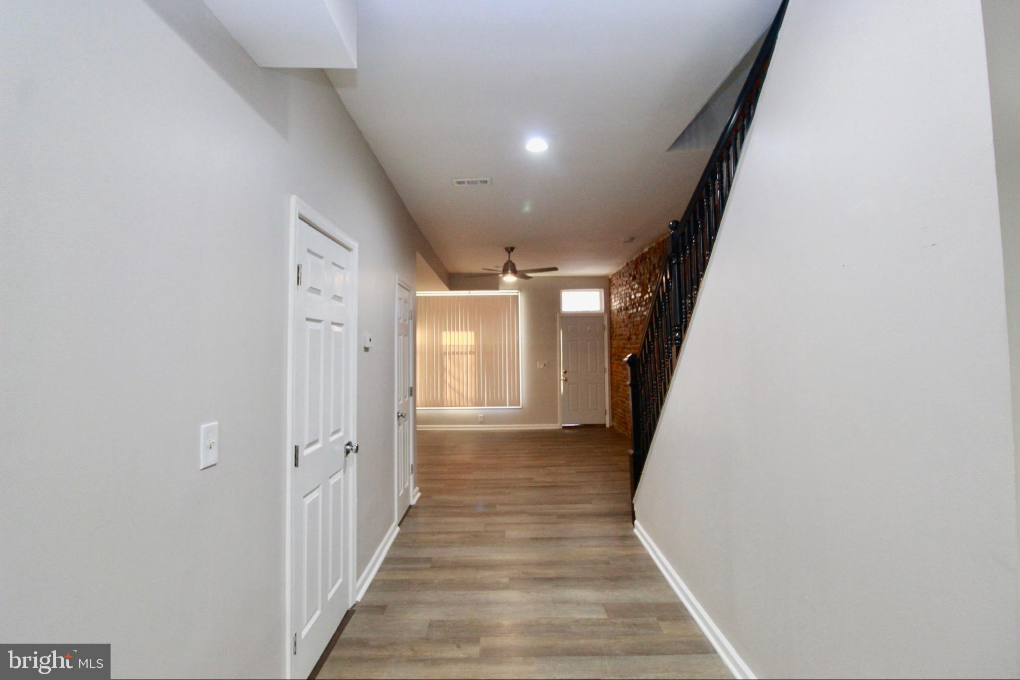 434 East 28th Street Baltimore, MD 21218 - Photo 8 of 37 a view of a hallway with wooden floor and staircase