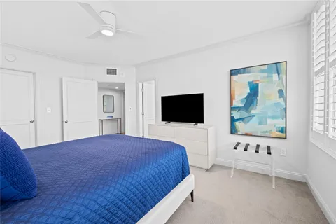 a bedroom with a large bed and a flat screen tv