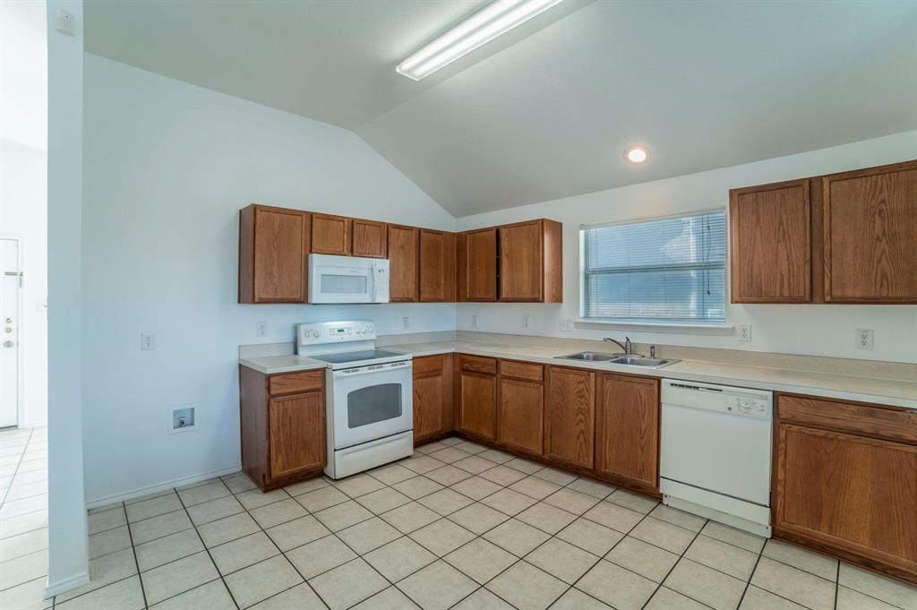6333 Pool View Drive Dallas, TX 75249 - Photo 15 of 37 a kitchen with stainless steel appliances granite countertop a sink and cabinets