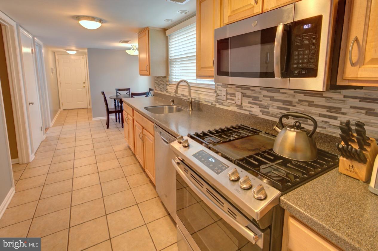 9015 Horton Road Laurel, MD 20708 - Photo 14 of 33 a kitchen with stainless steel appliances granite countertop a stove a sink and a microwave