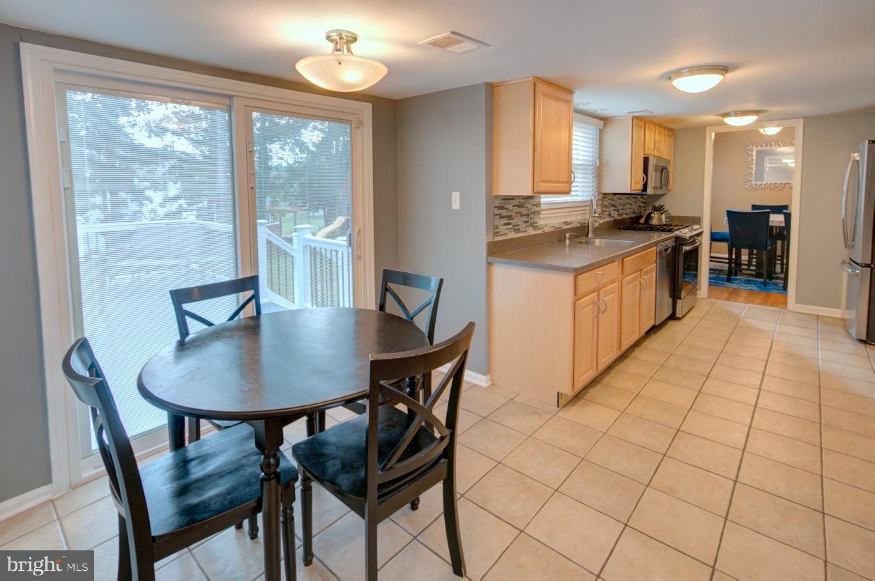 9015 Horton Road Laurel, MD 20708 - Photo 16 of 33 a kitchen with stainless steel appliances granite countertop a stove a refrigerator a kitchen island a table and chairs