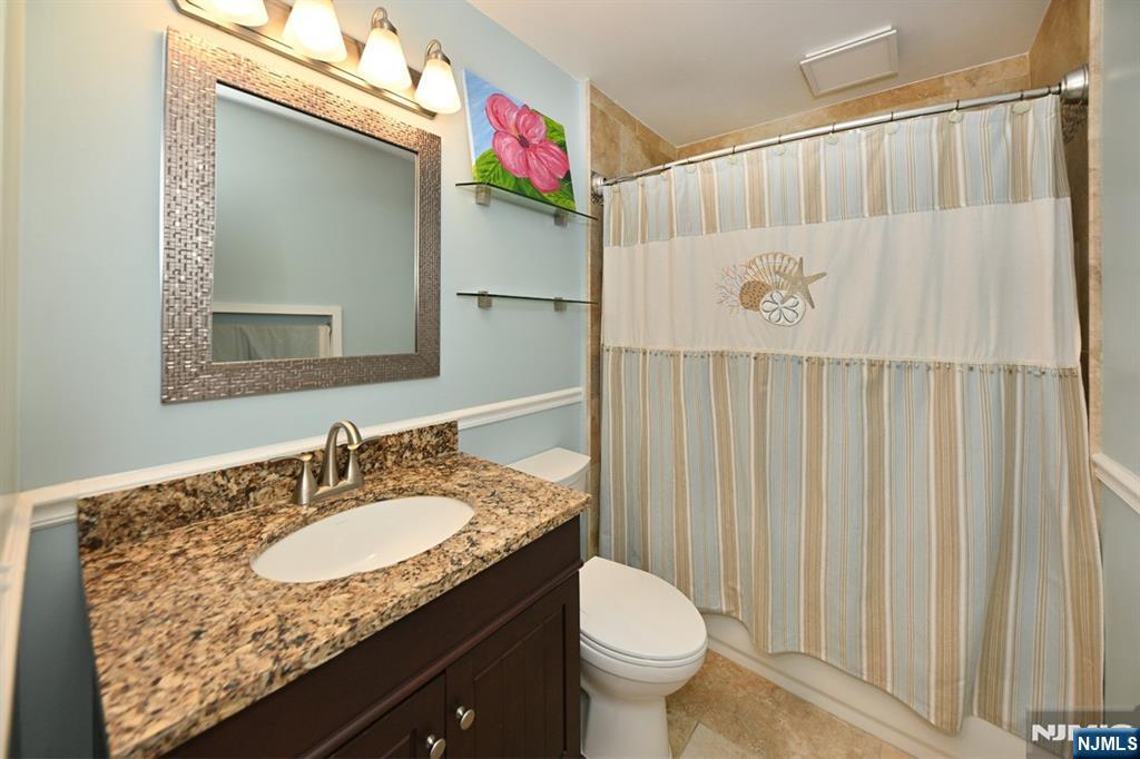 39 Niagara Street Dumont, NJ 07628 - Photo 20 of 40 a bathroom with a granite countertop sink and a mirror