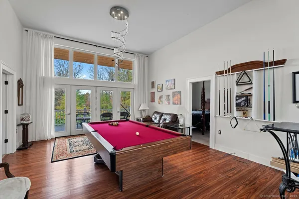 a room with furniture pool table flat screen tv and windows