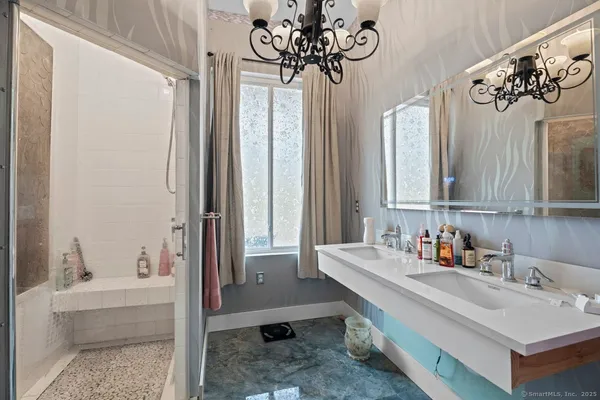a bathroom with a double vanity sink mirror and bathtub