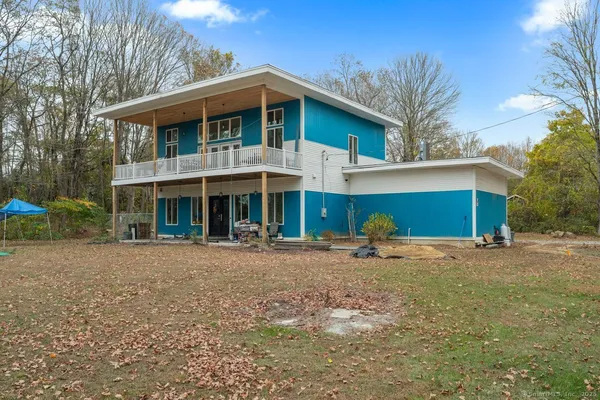 a front view of a house with a yard and trees