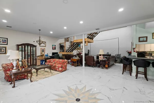 a living room with furniture and a gym machine with rug