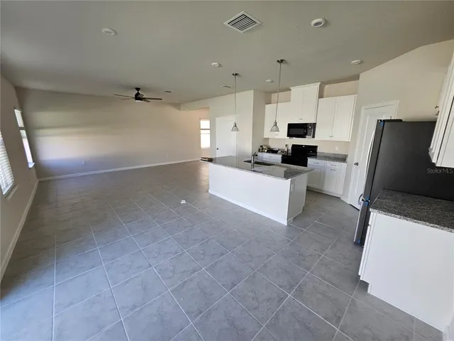 a large white kitchen with cabinets and a couch