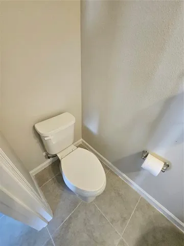 a white toilet sitting next to a white wall