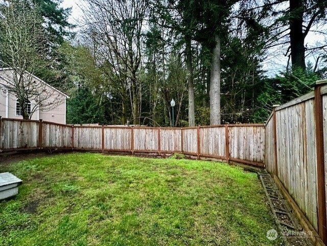 3419 Bittersweet Street Southeast Olympia, WA 98501 - Photo 15 of 15 a view of a backyard with wooden fence and a large tree
