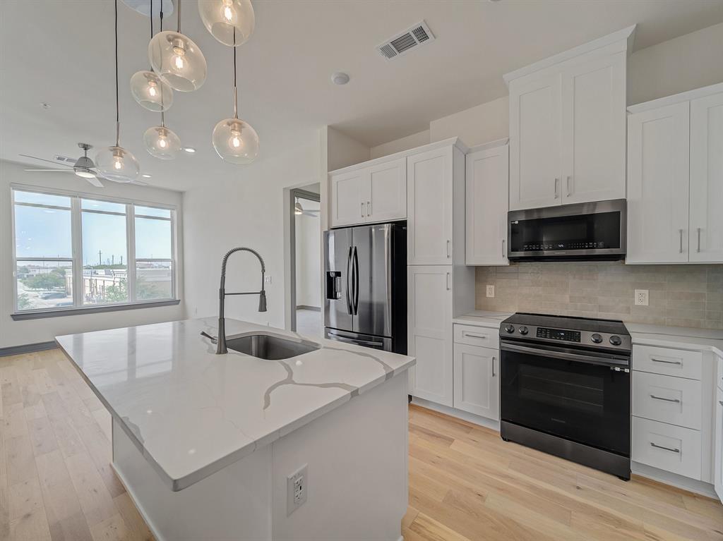 a kitchen with kitchen island a stove and a sink