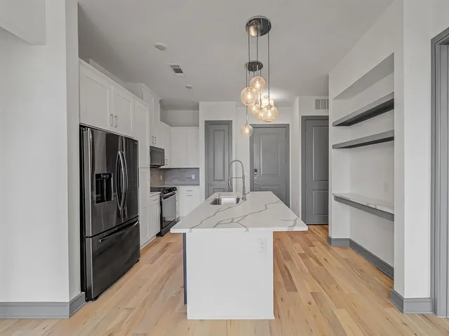 a kitchen with stainless steel appliances a sink stove and refrigerator
