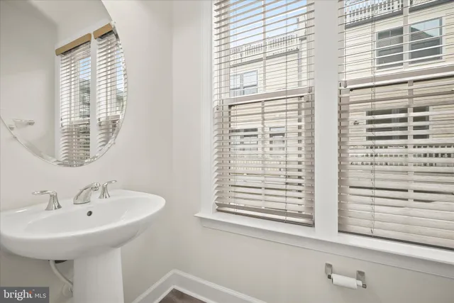 a kitchen with stainless steel appliances kitchen island granite countertop a refrigerator a oven a sink and white cabinets with wooden floor