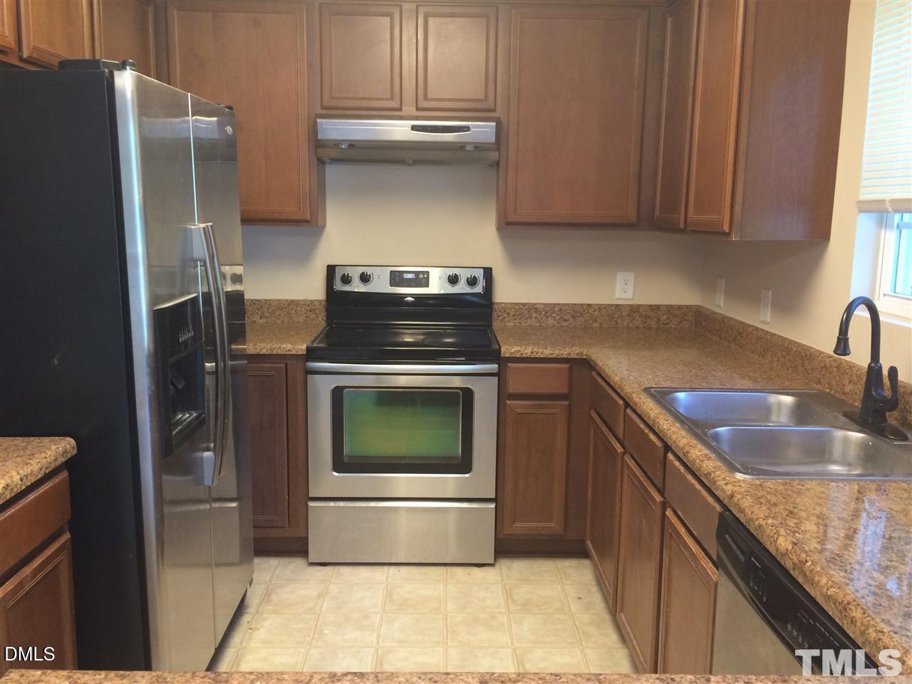 725 Perry Howard Road Fuquay-Varina, NC 27526 - Photo 5 of 16 a kitchen with a stove top oven and refrigerator