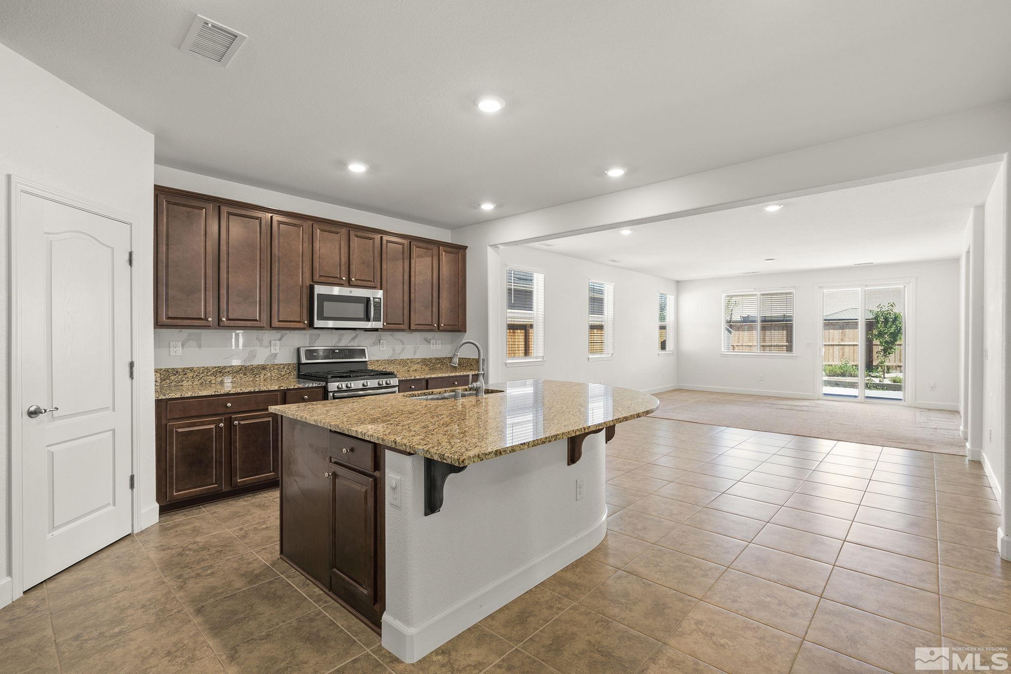 7360 Continuum Drive Reno, NV 89506 - Photo 6 of 28 a kitchen with stainless steel appliances granite countertop a stove top oven a sink dishwasher and a refrigerator