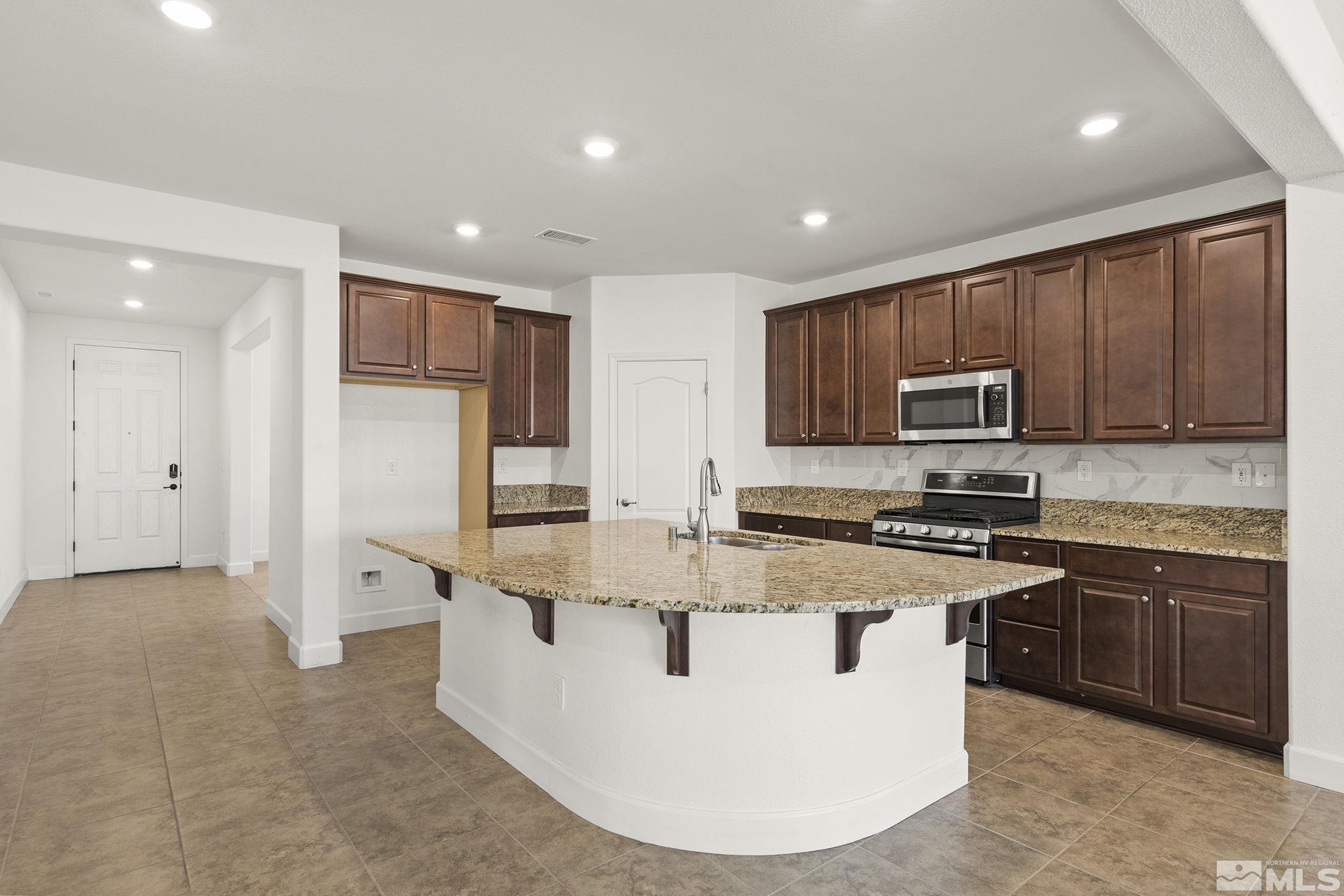 7360 Continuum Drive Reno, NV 89506 - Photo 7 of 28 a view of kitchen with stainless steel appliances granite countertop lots of white cabinets a refrigerator and a stove