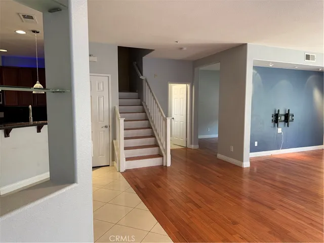 a view of a hallway with wooden floor and staircase
