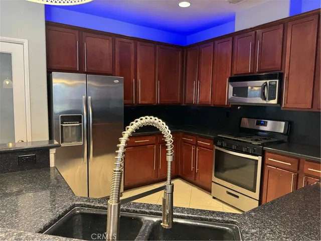 a kitchen with stainless steel appliances granite countertop a refrigerator and a stove top oven