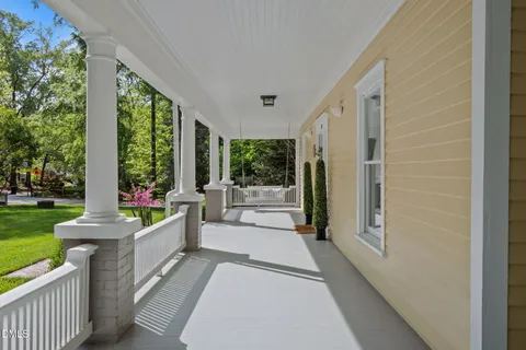 a front view of a house with porch and furniture