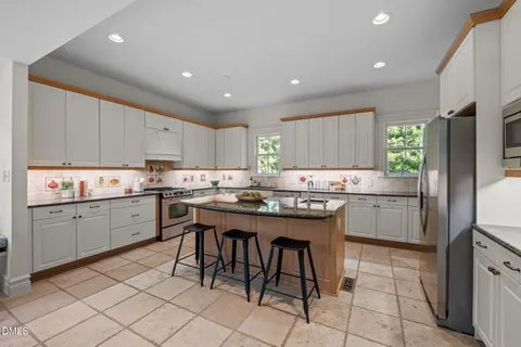 a room with stainless steel appliances a table and chairs in it
