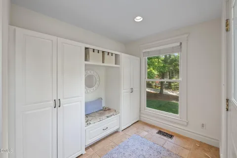 a view of an empty room with closet and a window