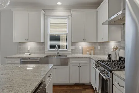 a kitchen with stainless steel appliances granite countertop a sink stove and cabinets