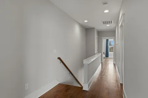 a view of a hallway with wooden floor