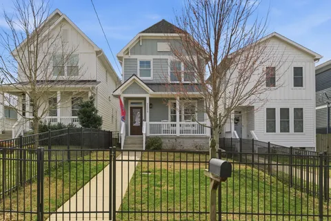 a view of a brick house with many windows next to a yard