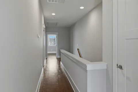 a view of a hallway with wooden floor