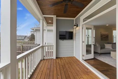 a view of a porch with wooden floor and outdoor seating