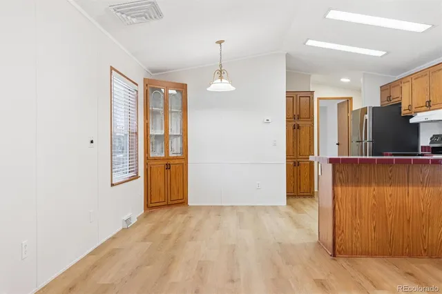 a view of a kitchen with wooden floor and a ceiling fan